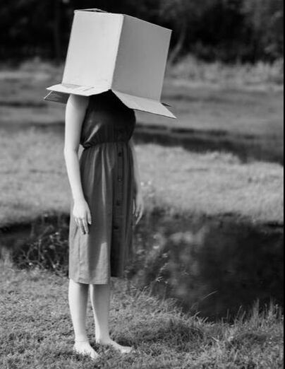 Woman feeling regret with a box on her head
